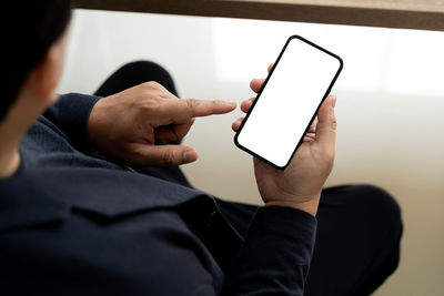 Midsection of man using mobile phone