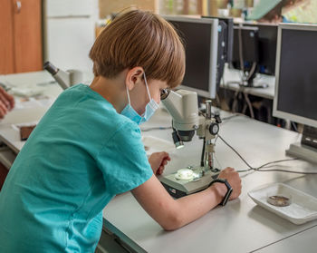 Boy examines the preparations under the microscope. classroom activities. practical lesson.