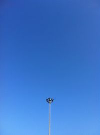 Low angle view of floodlight against clear blue sky