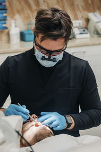 Dentist examining patient's teeth in clinic