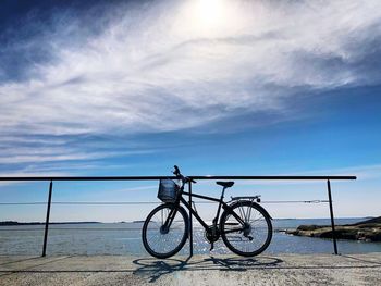 Bicycle on beach against sky