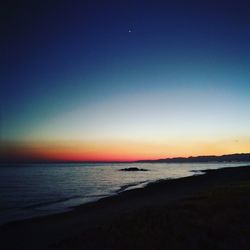 Scenic view of sea against clear sky at sunset