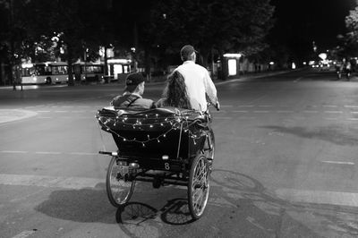 Rear view of couple sitting on pedicab