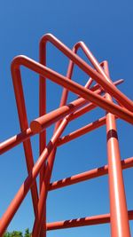 Low angle view of playground against clear blue sky