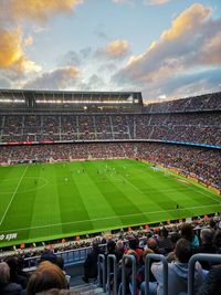 Group of people on soccer field against sky