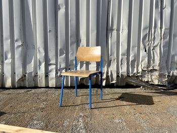 Empty chairs against abandoned building