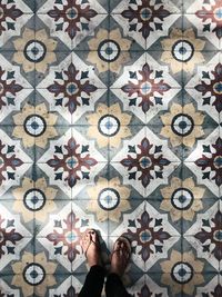 Low section of woman standing on tiled floor