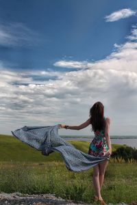 Full length of woman standing on field against sky