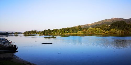 Scenic view of lake against clear blue sky