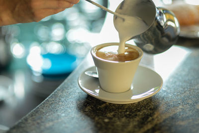 Hands of young adult caucasian female barista at work preparing