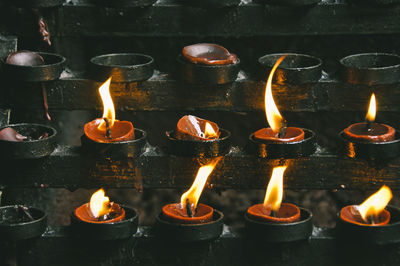 Full frame shot of burning candles in temple