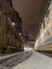 Street amidst illuminated buildings in city at night