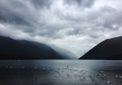 Scenic view of sea and mountains against sky