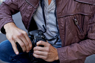 Midsection of man holding gun