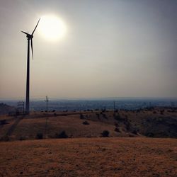 Wind turbines on land against sky