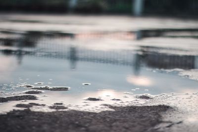 Reflection of clouds in puddle on lake during rainy season