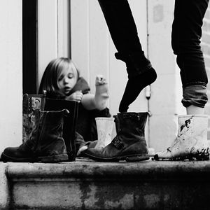 Low section of woman wearing shoes with girl in background