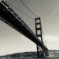 Low angle view of suspension bridge against sky