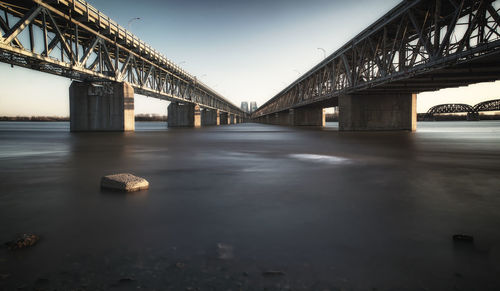 Bridge over river against sky in city