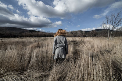 Woman standing on field against sky