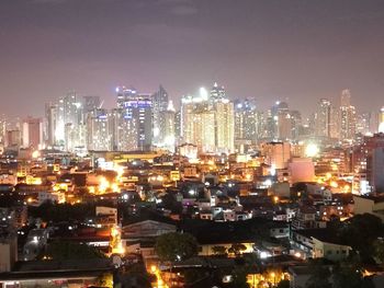 Illuminated cityscape against sky at night