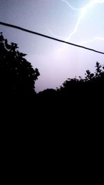 Low angle view of silhouette trees against sky