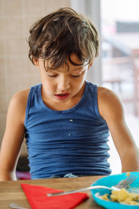 Boy eating and spilling food on his shirt