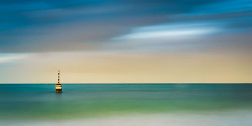 Lighthouse by sea against sky