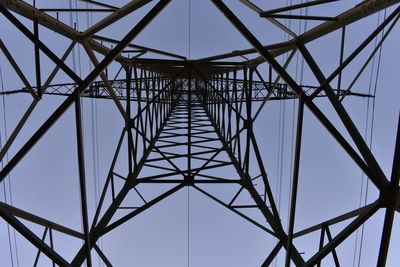 Low angle view of electricity pylon against clear sky