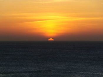 Scenic view of sea against orange sky