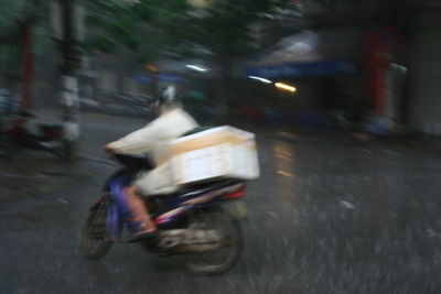 Blurred motion of people riding bicycle on road