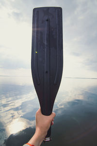 Close up hand holding water paddle with seascape concept photo