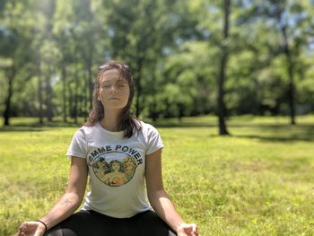 Full length of teenage girl sitting on field