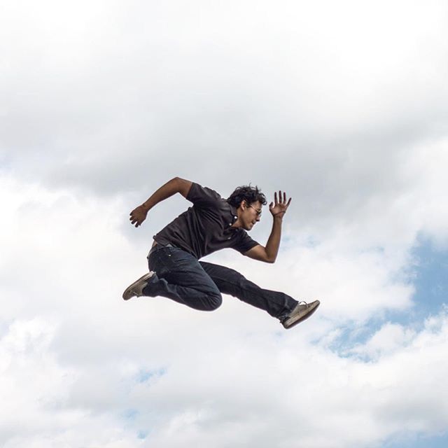 low angle view, mid-air, sky, lifestyles, leisure activity, full length, jumping, cloud - sky, freedom, flying, fun, cloudy, skill, arms outstretched, vitality, motion, young adult, enjoyment