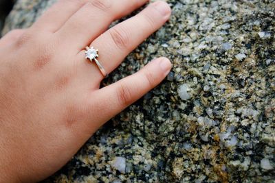 Cropped hand of woman wearing ring while touching marble