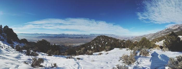 Scenic view of snow covered mountains against blue sky