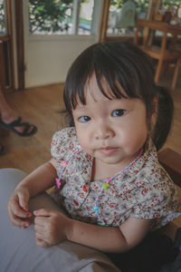 Portrait of cute girl sitting at home