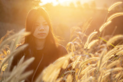 Portrait of beautiful young woman on field