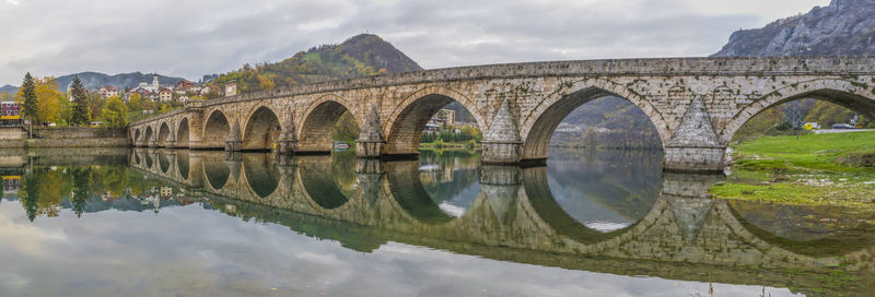 Arch bridge over river against sky