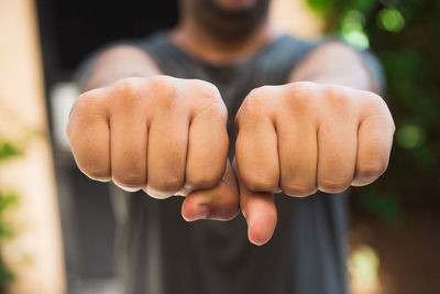 Midsection of man showing fist