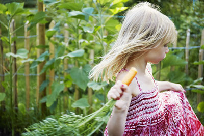 Girl holding ice cream cone outdoors