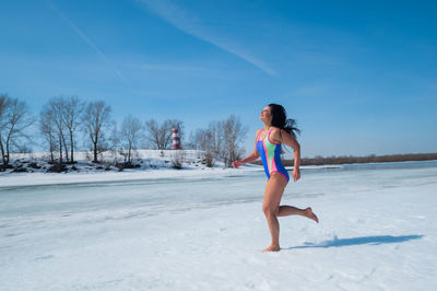 Rear view of woman standing on snow covered landscape