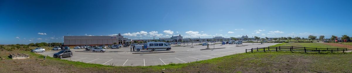 Panoramic view of ferris wheel against blue sky