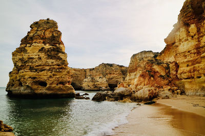 Rock formations by sea against sky