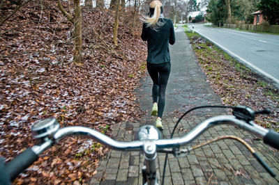 Woman running on street against bicycle