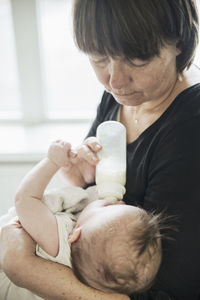 Grandmother bottle feeding baby