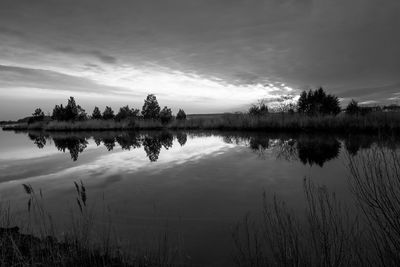 Scenic view of lake against sky at sunset