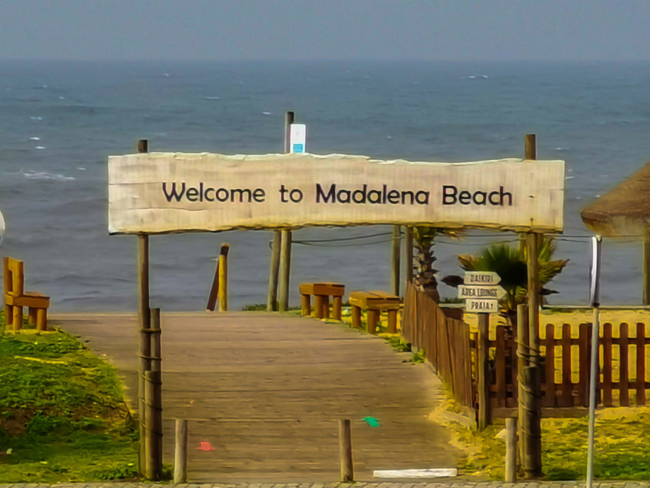 INFORMATION SIGN ON WOODEN POST AGAINST SEA