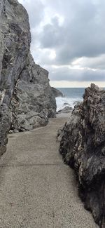 Rock formation on beach against sky