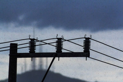 Low angle view of silhouette pole against sky